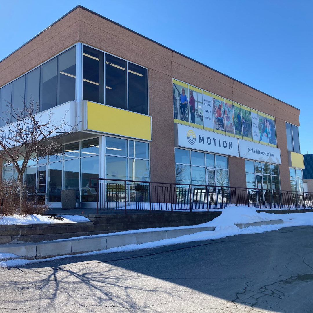 Motion Barrie - Exterior View of Building with front door and window graphics on upper windows on side of building