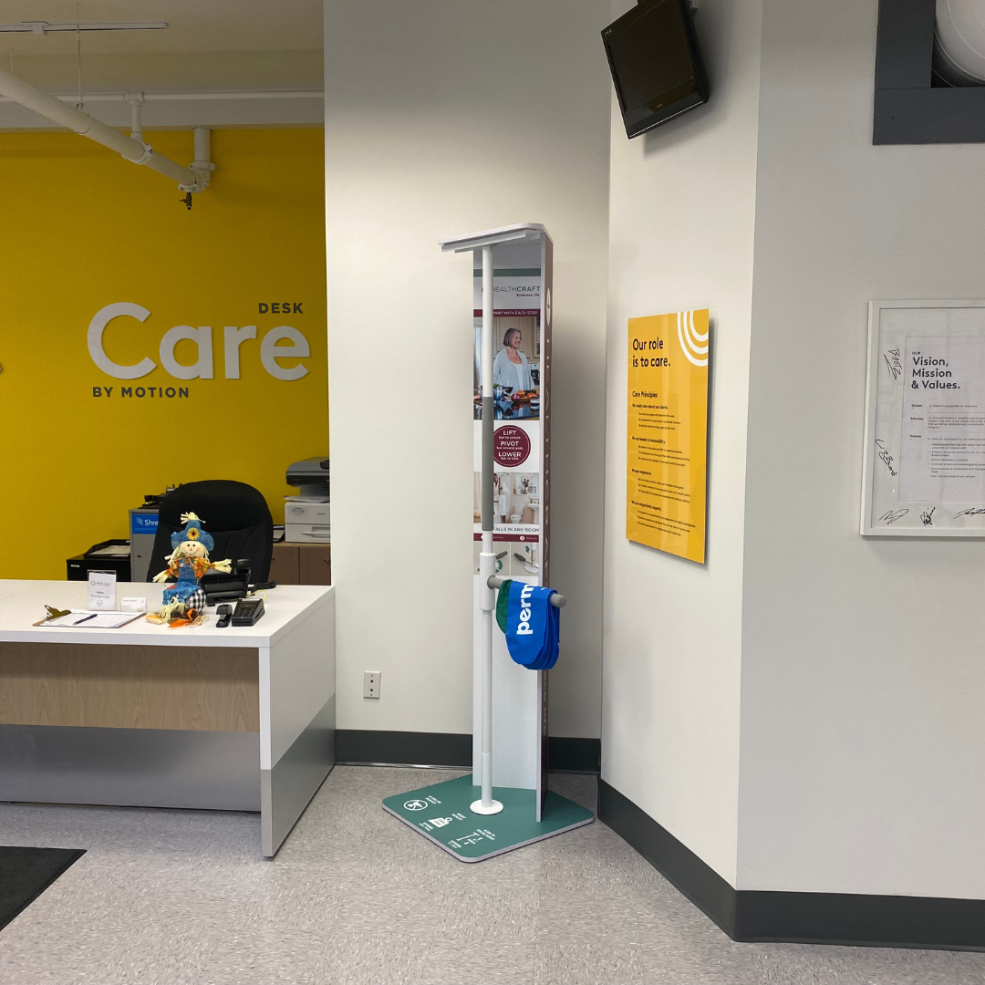 Motion Kelowna Care Desk with yellow wall behind it.