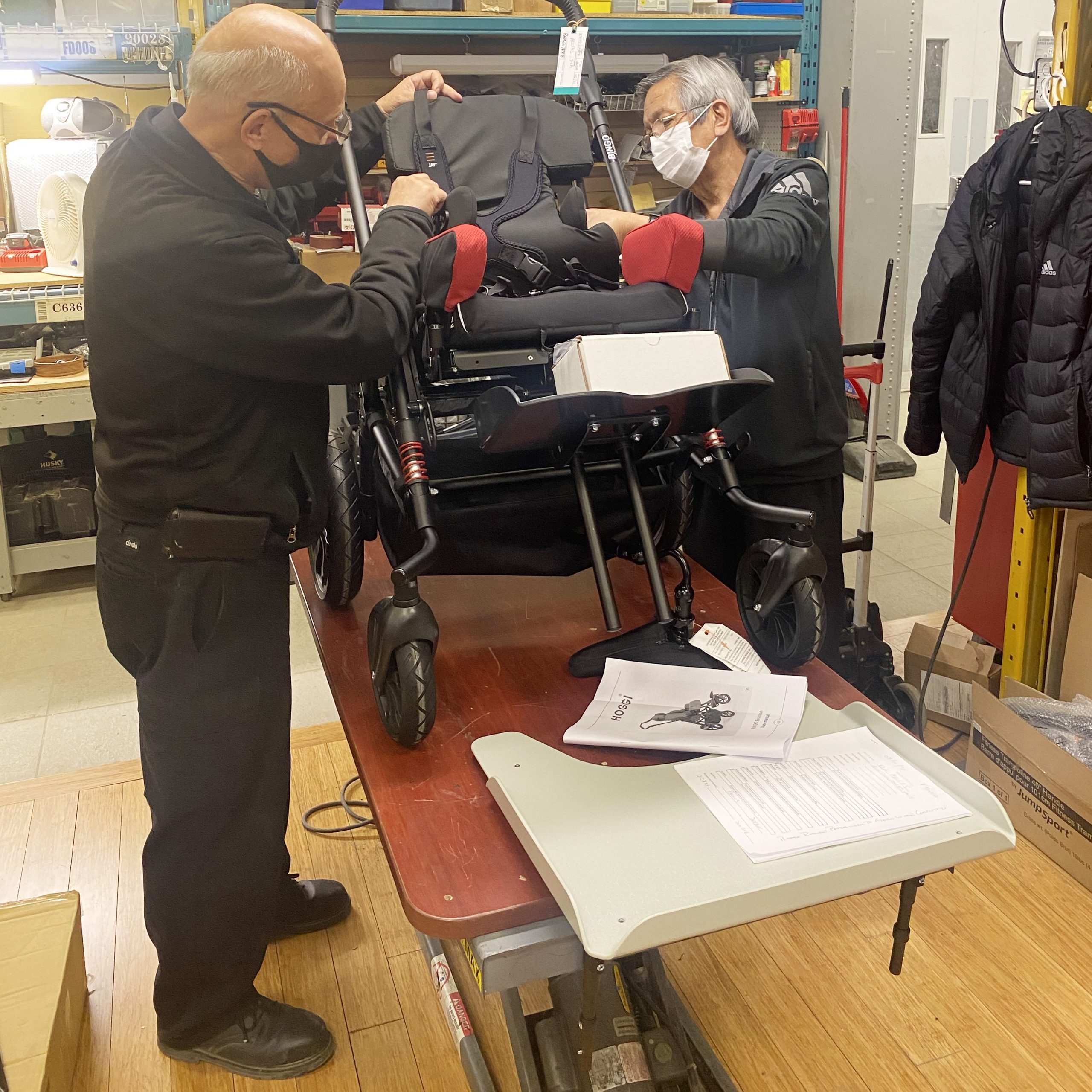 Two men fixing a wheelchair