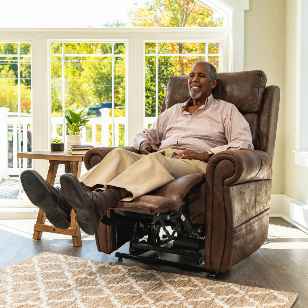 Smiling man reclined in brown leather power lift recliner