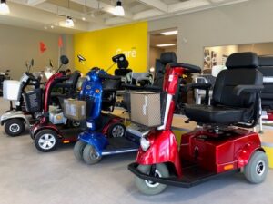 Mobility scooter lined up in Motion showroom with yellow care desk wall in background