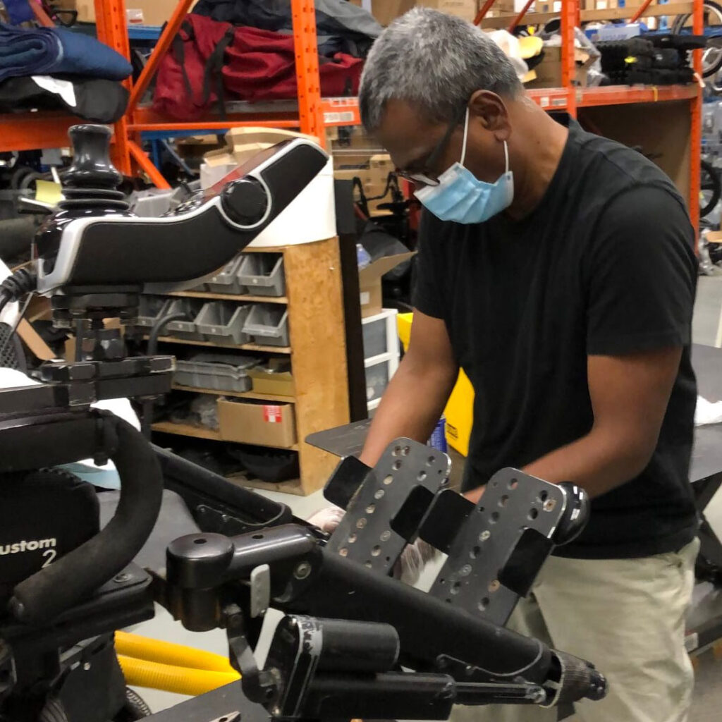 Motion technician working on mobility equipment in the warehouse.