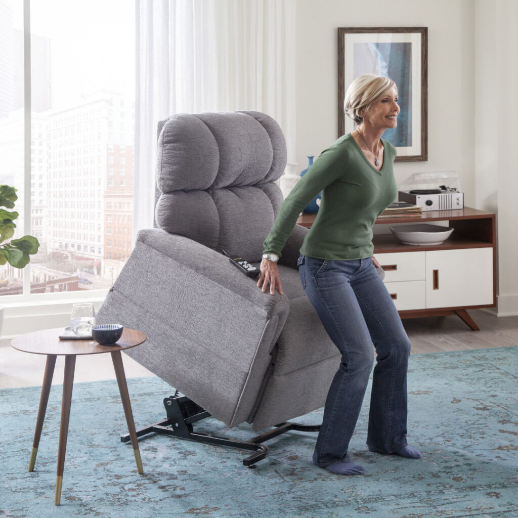 Smiling woman being raised from gray fabric power lift recliner