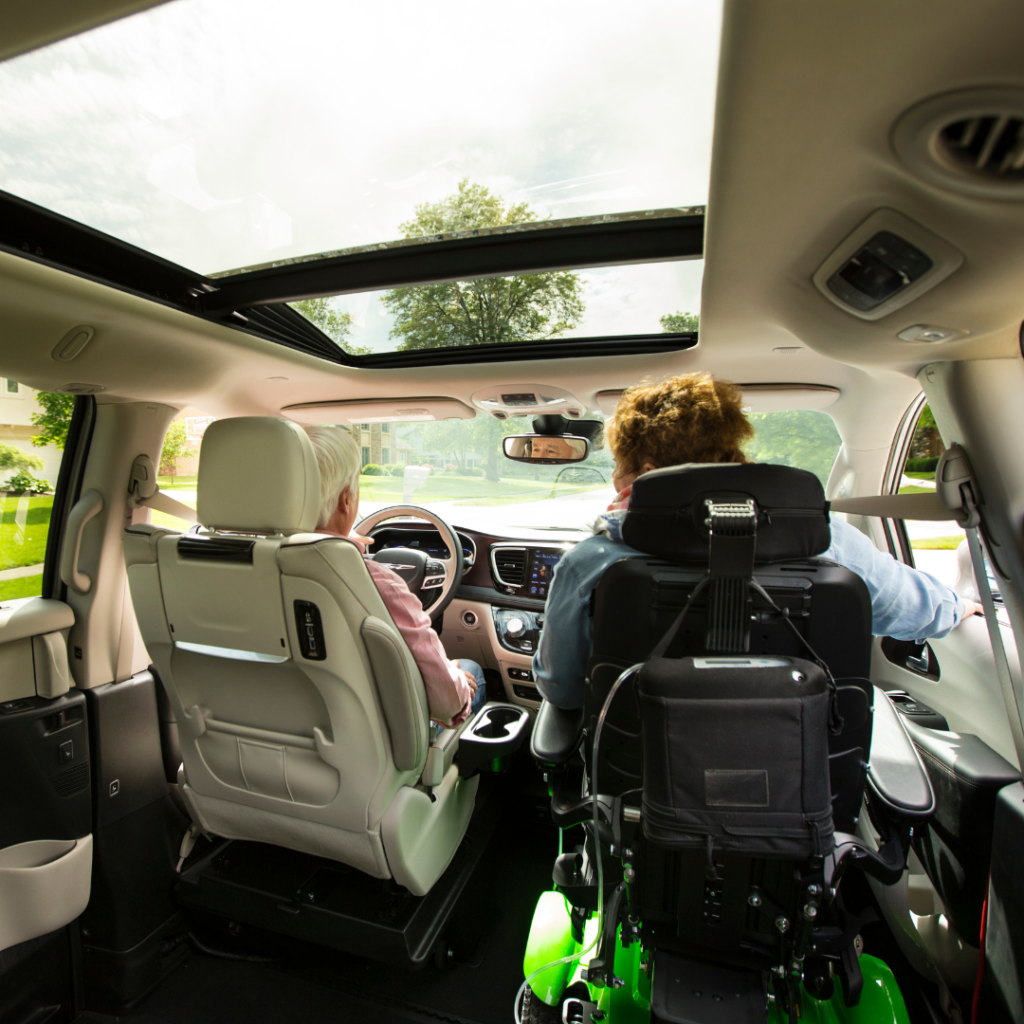 Interior view of accessible vehicle from behind front seats with person in power wheelchair in passenger spot