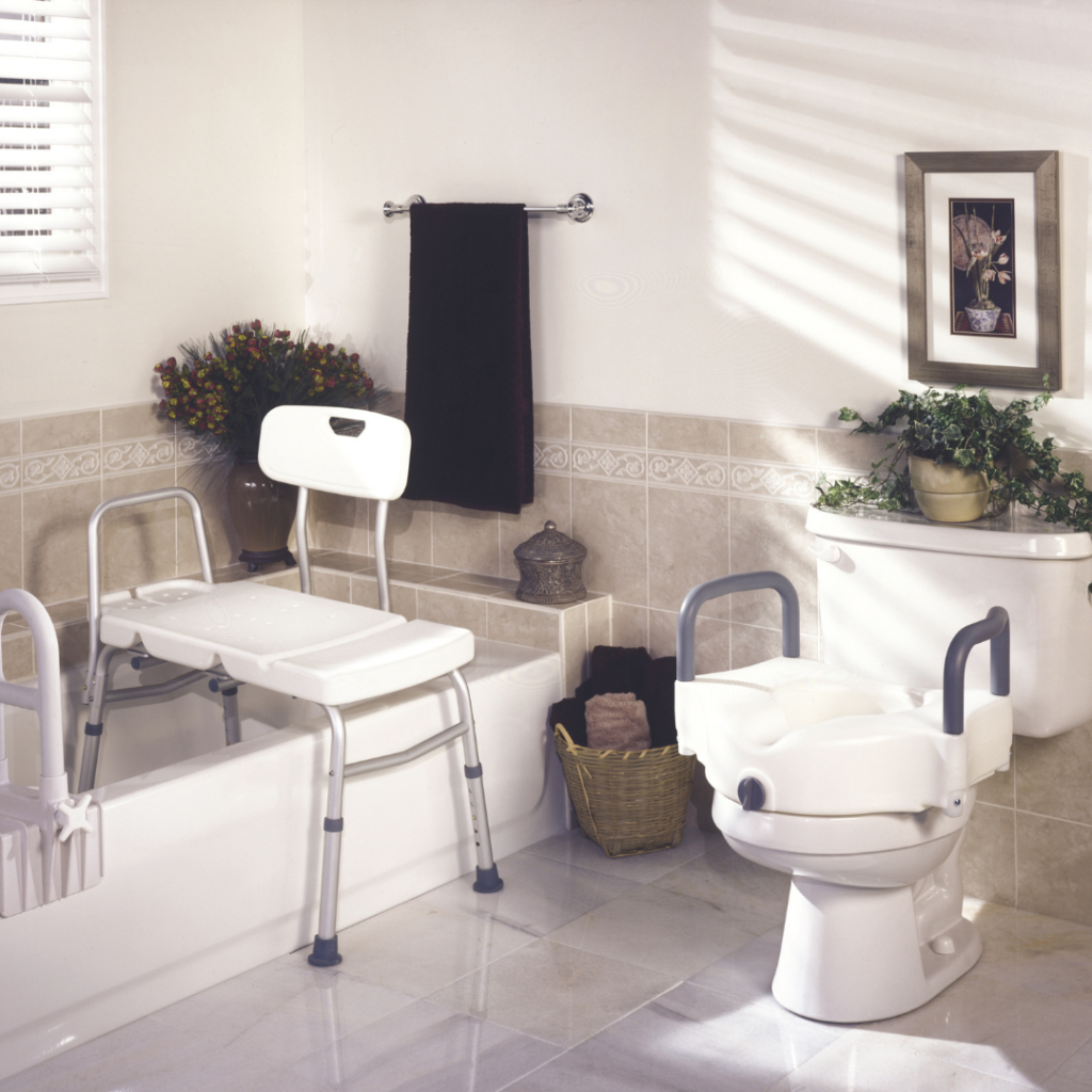 Neutral bathroom featuring safety items including a raised toilet seat, bath chair with back and tub rail. 