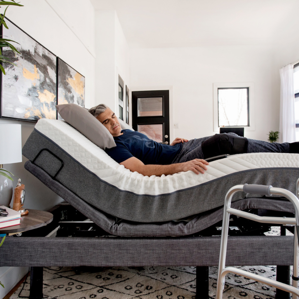 Man sleeping on an adjustable bed with walker in the foreground
