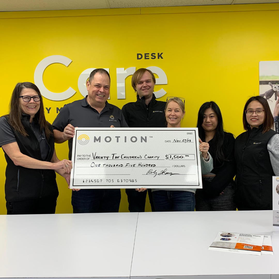 Motion Calgary team members holding a novelty cheque representing a donation to Variety the Children's Charity of Alberta