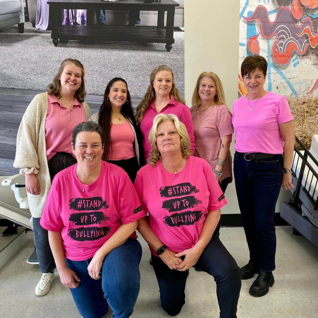 A group of Motion employees wearing pink for Pink Shirt Day. The group is in a Motion Showroom.