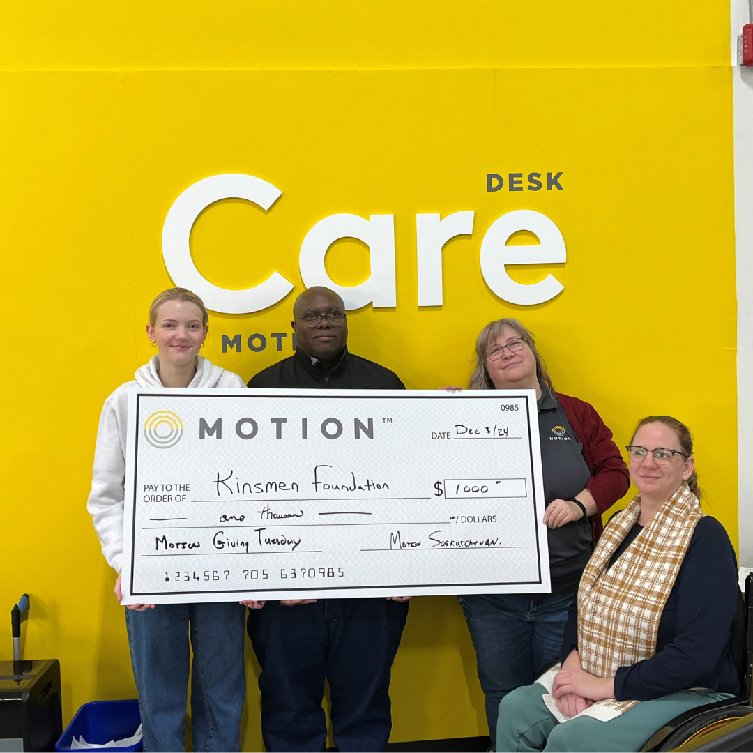 Members of the Motion Saskatoon team pictured holding up a novelty cheque to display a $1000 donation to the Kinsmen Foundation for Giving Tuesday.