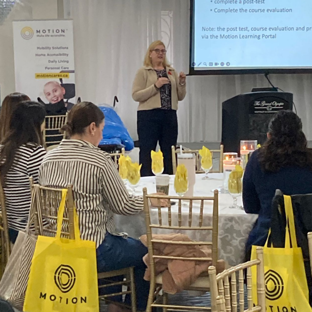 Linda Norton presenting from the stage at a Motion Rehab Expo.