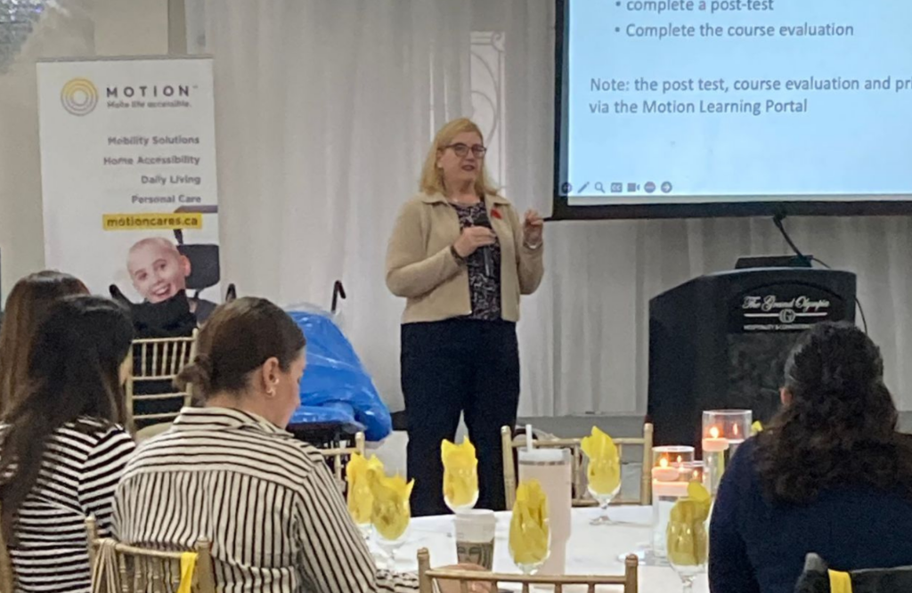 Linda Norton presenting from the stage at a Motion Rehab Expo.