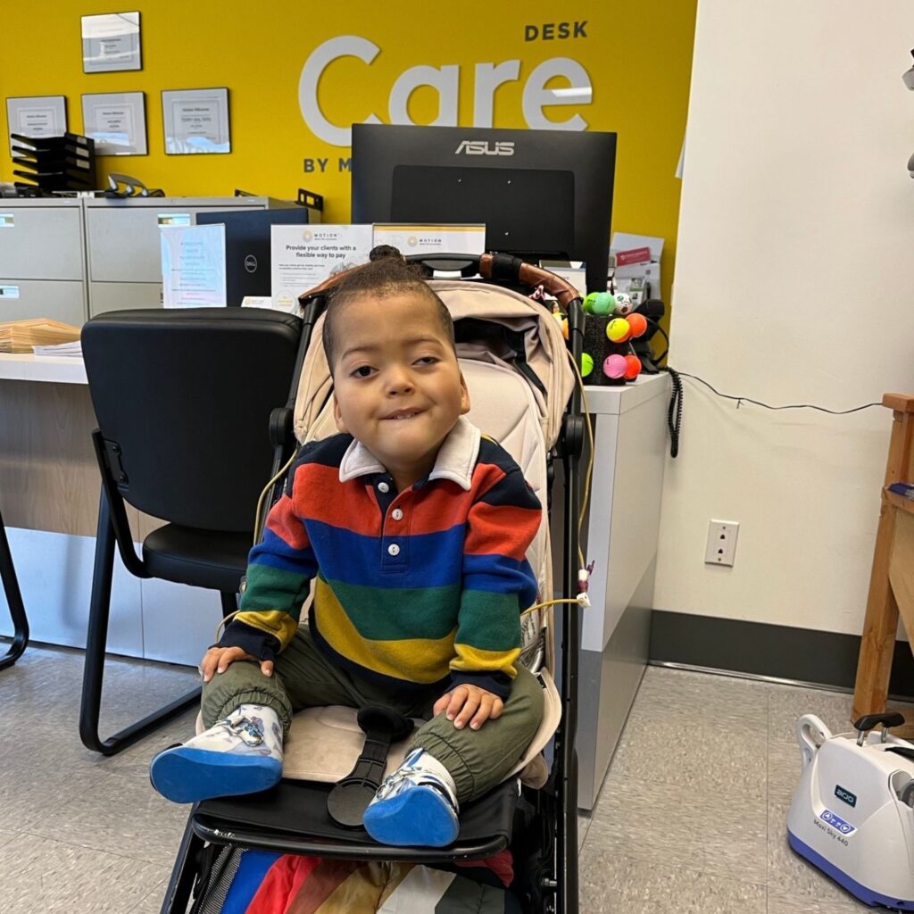 Motion client Maverick in front of a Motion care desk with a yellow wall in the background. 